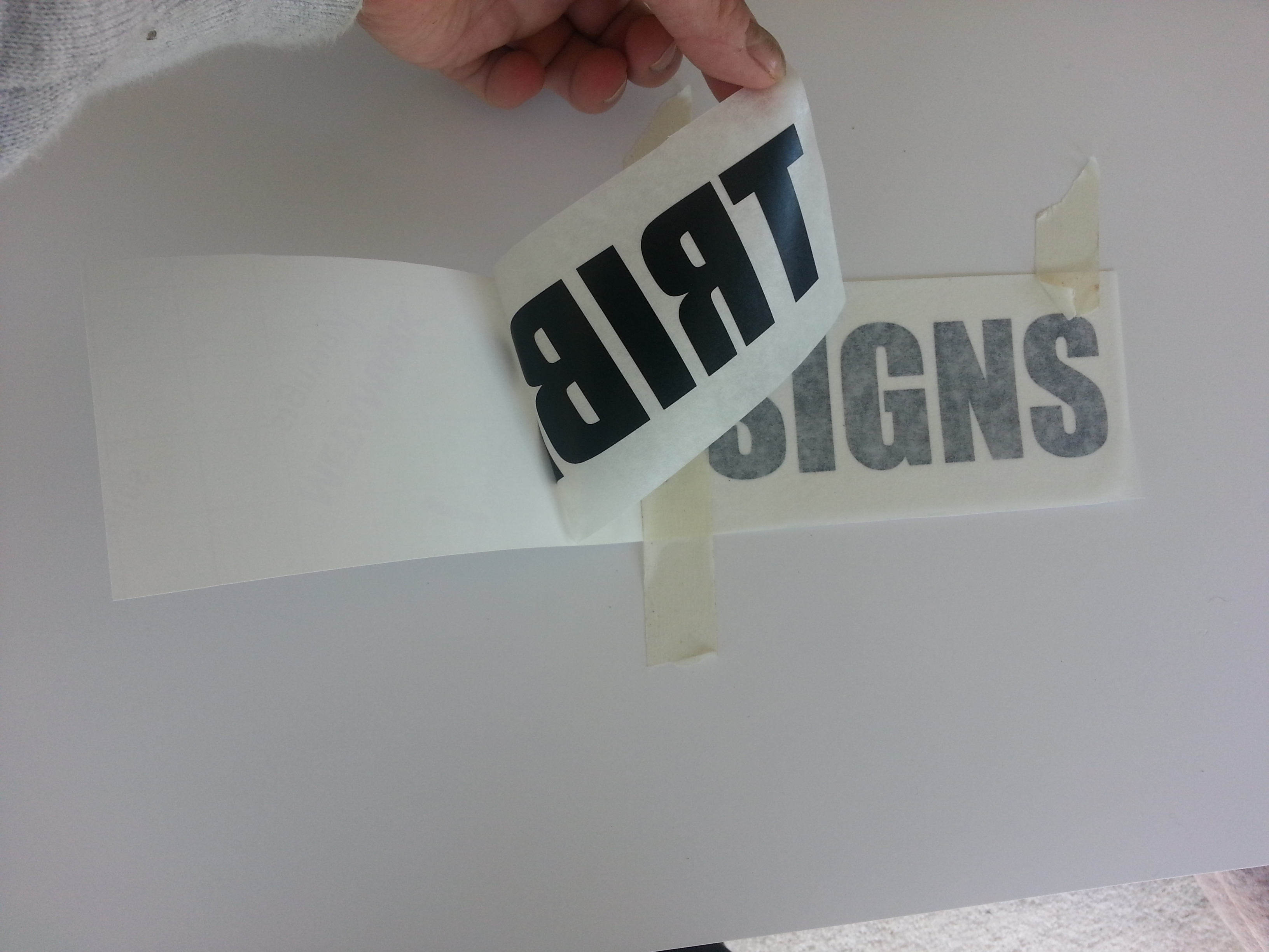 vinyl lettering example showing backing paper, application tape and the vinyl